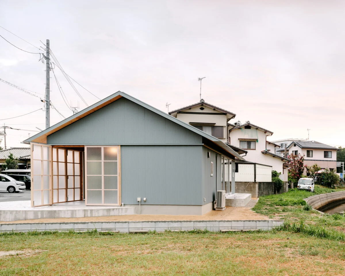 外観。「倉庫のような家」という要望を、ガルバリウム鋼板とポリカーボネート板の外壁で表現した。そっけなくなりすぎないようにと軒裏の木目のディテールや、家をぐるりと一周するラインを施すなどデザイン性が高められており、前を通る人の目を引く
