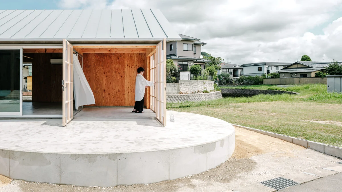 外観。建物の形は横長でシャープだが、川の流れと円形のテラスのラインがリフレインして柔らかな印象の家となった