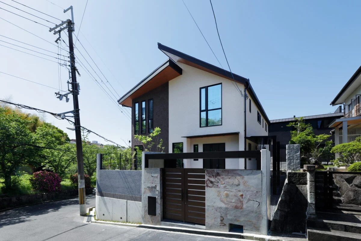 北側から見た外観。切妻屋根の先端部分の長さを変えることで変化を出し、他にはない特徴を出している。門扉の高級感のある石はリビングなどでも使用し、統一感を出した
