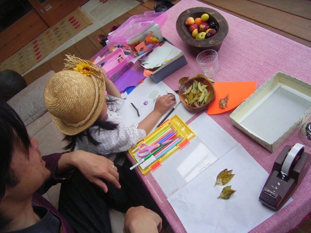 お子さんが小さかった頃のワンシーン。小枝や落ち葉を使い、ウッドデッキでお絵描きを楽しむ。庭で拾ったものも、半戸外のウッドデッキなら汚れを気にせずに広げられ、子どもは好奇心のままにのびのびと遊べる
