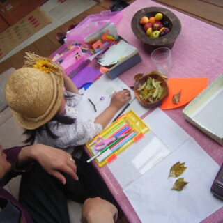 お子さんが小さかった頃のワンシーン。小枝や落ち葉を使い、ウッドデッキでお絵描きを楽しむ。庭で拾ったものも、半戸外のウッドデッキなら汚れを気にせずに広げられ、子どもは好奇心のままにのびのびと遊べる