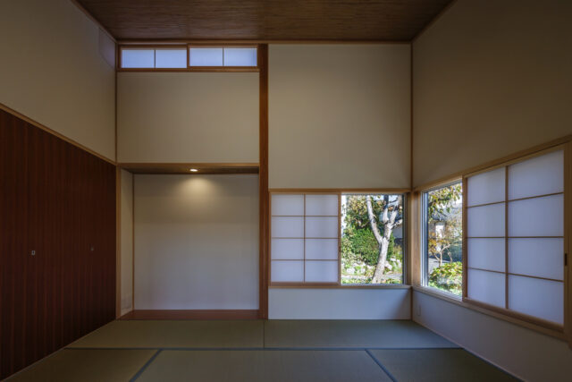 北側の和室。『逢瀬町の平屋』は北に向かって天井が高くなるためこの和室も天井が高く、ハイサイドライトやコーナー窓から外の景色や光も感じられ、心地よい開放感がある。左の上部には玄関ホール側からのぼるロフト収納があり、普段使わないものをしまってすっきりと生活できる