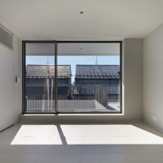 3階寝室。2階とは違い、窓からの風景は住宅街そのものといった印象。画像左の縦格子の裏にはエアコンを設置。家具がお好きな奥様のため、これから置かれる家具が引き立つような、なるべく主張しない内装とした
