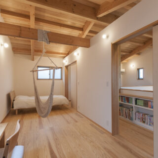 2階子ども室１、２。現在はハンモックを外し、建具を入れて2部屋にした。壁が入りコンパクトな空間になっても、天井が2階全体で繋がっているのがわかるため圧迫感がなく、また安心感を得られる。扉を開ければ、本やおもちゃなどが置いてある子どもスペースまで意識が拡張される


