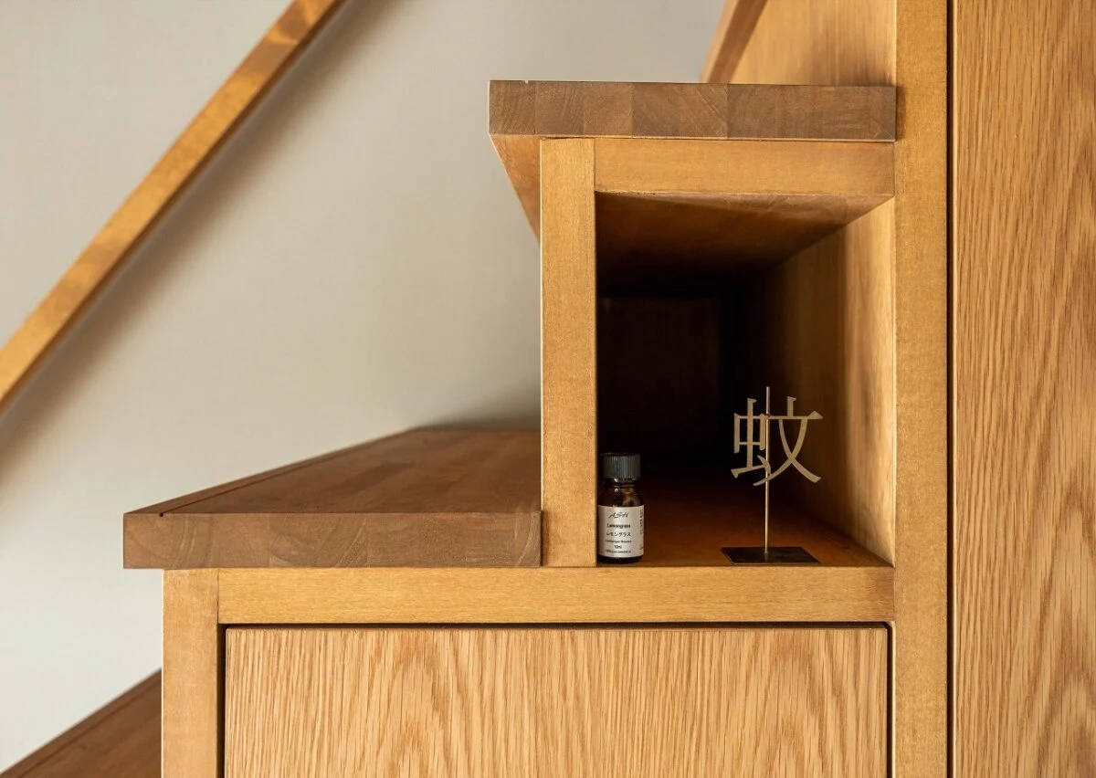 LDK内にあるロフトへの階段には、階段下収納を造作。一部はディスプレーも楽しめるようにデザイン。遊び心のある飾り棚に、遊び心のある蚊取り線香ホルダーが置かれている