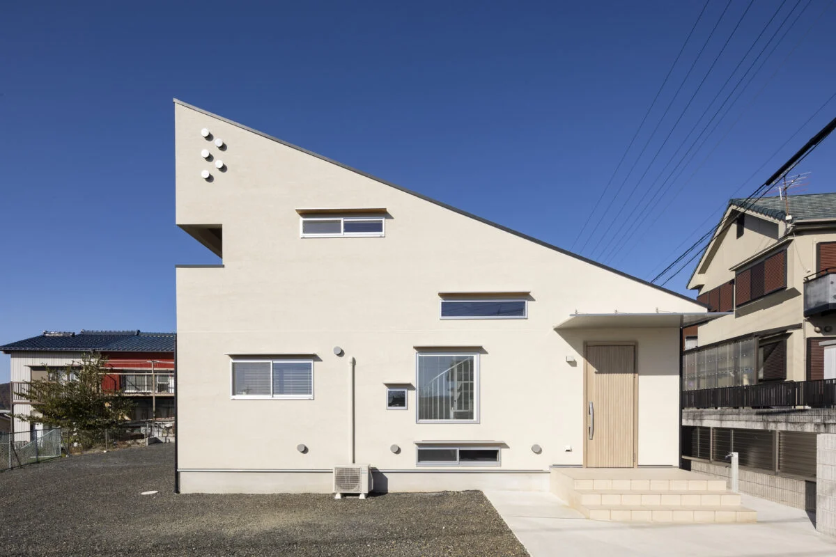 南の外観。建物右端が玄関。窓は猫が外を眺めるためにつくったものが多く、地窓やハイサイド窓がランダムに配されている。K家の猫たちは窓の外を見ていて帰宅する家族に気づくと、邸内で待ち構えているそう
