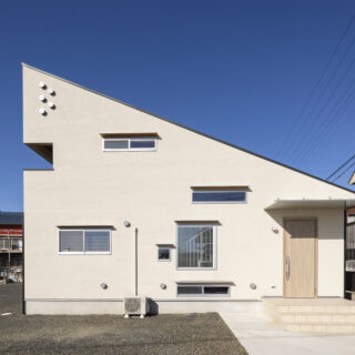 南の外観。建物右端が玄関。窓は猫が外を眺めるためにつくったものが多く、地窓やハイサイド窓がランダムに配されている。K家の猫たちは窓の外を見ていて帰宅する家族に気づくと、邸内で待ち構えているそう

