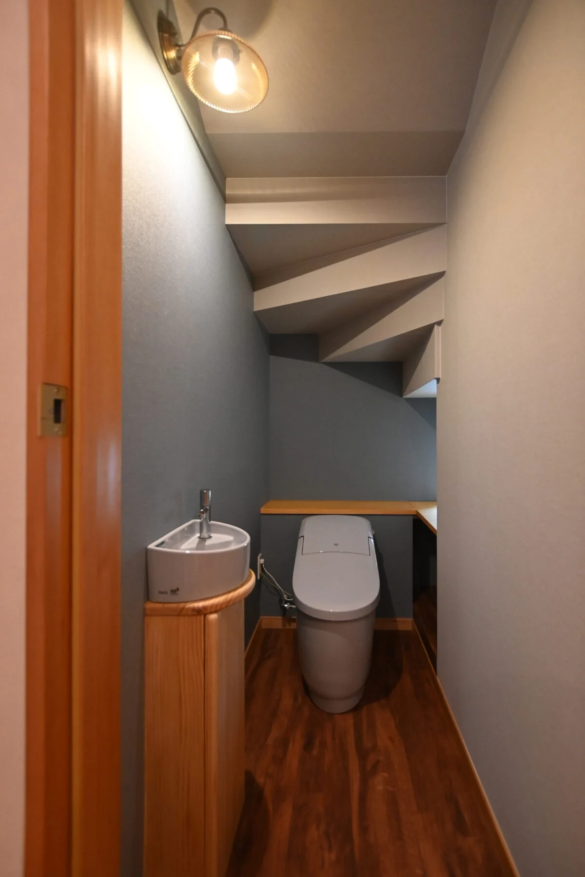 階段の下に設けられた1階のトイレ。リビングから直接トイレに入る間取りは避けたいという奥様の要望により、この場所に決められたそう