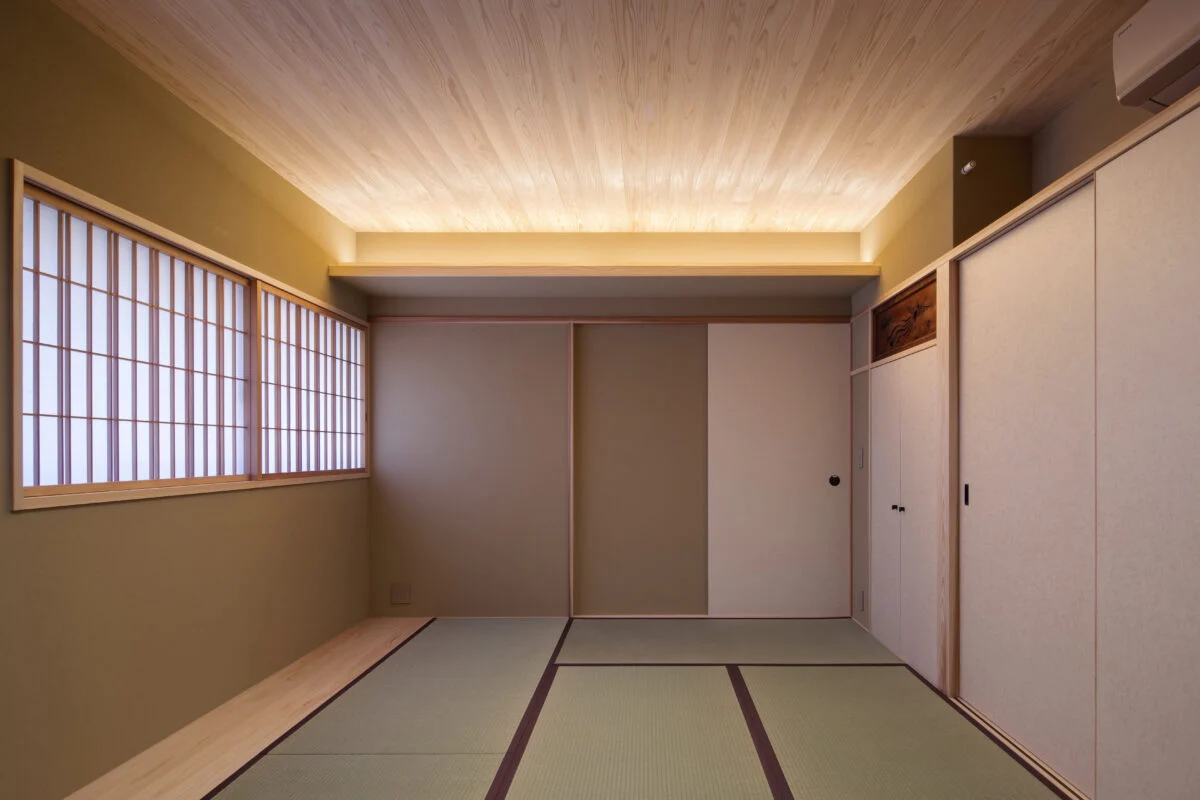 親世帯１階寝室。右壁面の引き戸のうち、一番奥は階段下収納。手前は押入れ。間接照明によって、寝室らしい、優しく落ち着きのある部屋になった