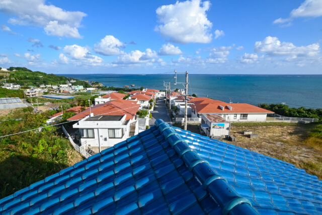 空と海に映える屋根の青い瓦は特注品。家から海へと続くリゾート分譲地の赤瓦との対比も心憎い
