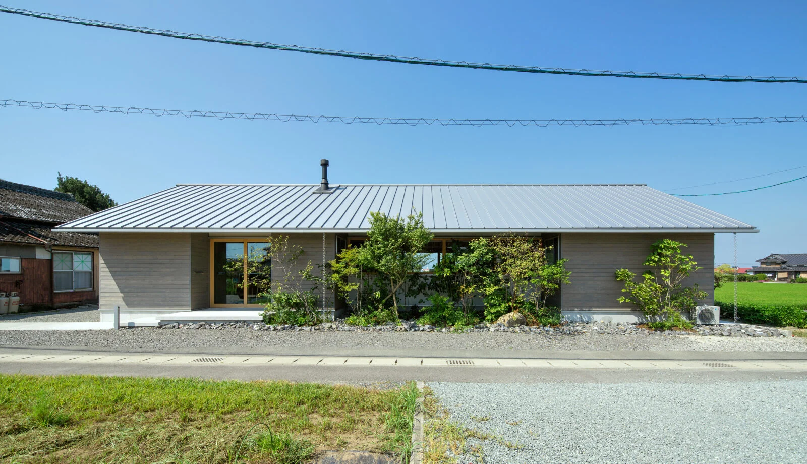 出入り自由、誰もが使える通り土間。 美しい田園風景になじむ、切妻屋根の家