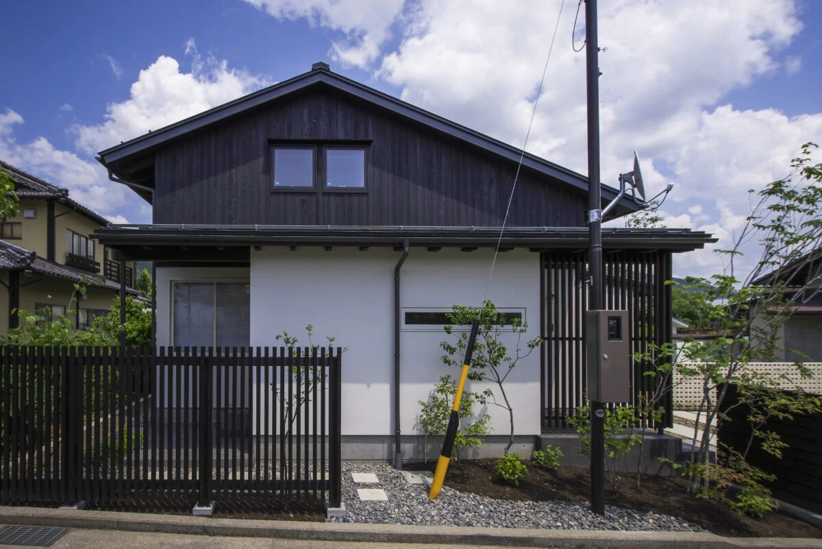 それぞれの屋根がつくる表情 − 2階を北側（写真左）に寄せることで、南側（写真右）の軒先が低くなる仕掛けが見て取れる。2階は屋根裏部屋のように見えるが目の錯覚を利用したもので、実際には問題のない室内高を確保している