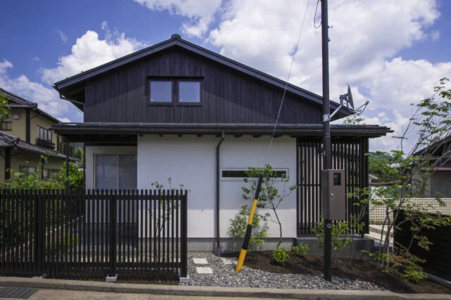 それぞれの屋根がつくる表情 − 2階を北側（写真左）に寄せることで、南側（写真右）の軒先が低くなる仕掛けが見て取れる。2階は屋根裏部屋のように見えるが目の錯覚を利用したもので、実際には問題のない室内高を確保している