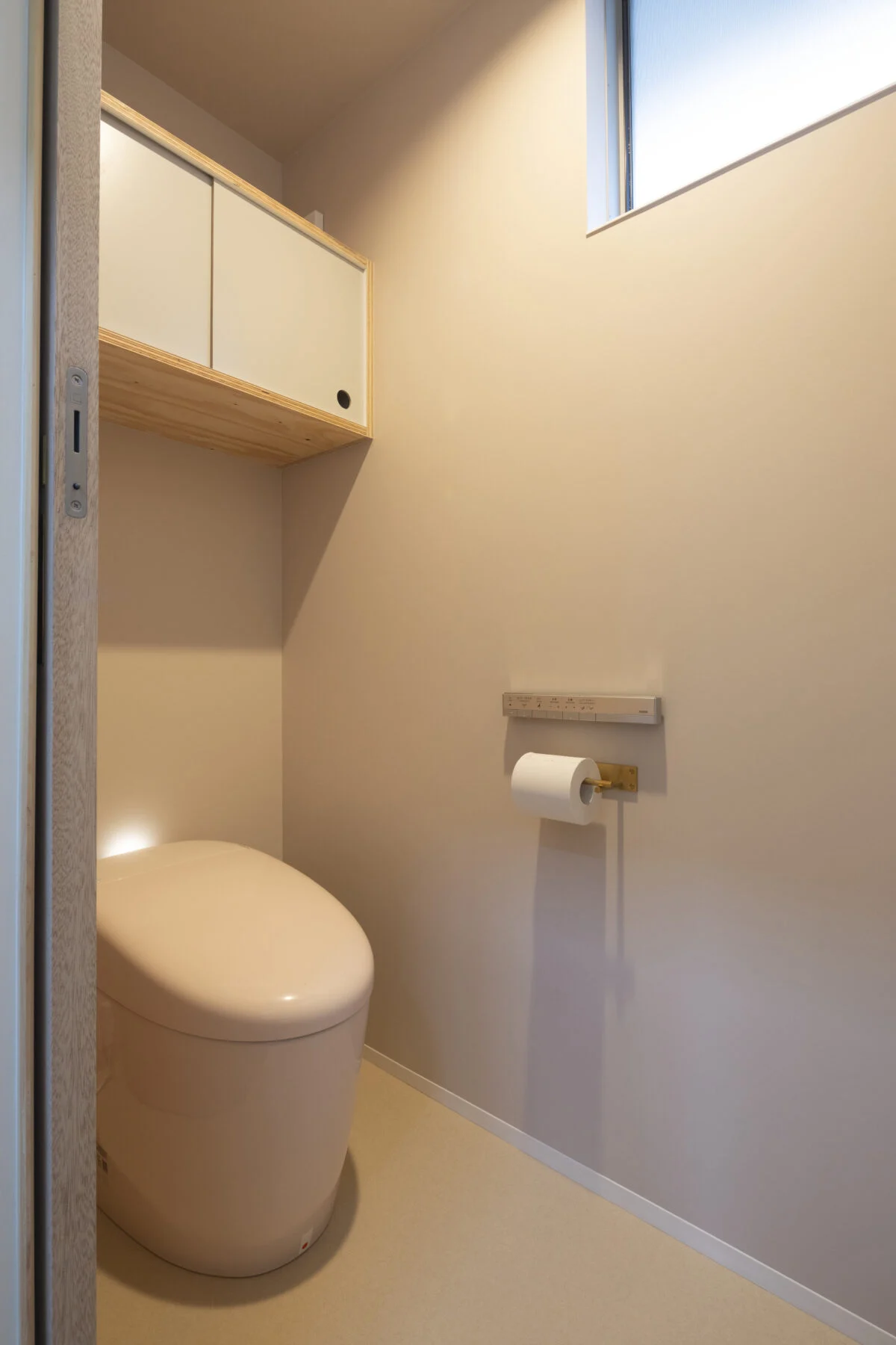 トイレの壁は淡いピンク。洗面室など生活空間以外の場所は、空間ごとにほんのり壁の色味を変えている