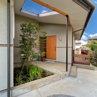 兄世帯の奥にある弟世帯の上り框前は、屋根が一部切り取られ中庭のような空間が。兄世帯のリビングから緑が感じられるという。