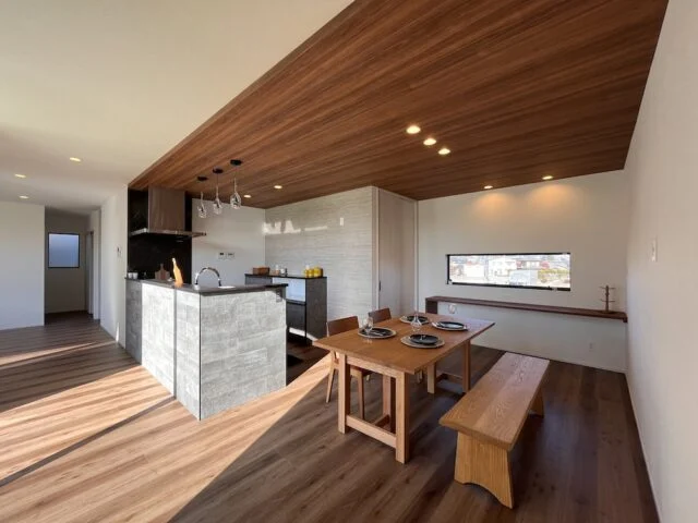 キッチンの天井は奥様の希望で、木目の下がり天井に。キッチンの裏側には収納力に優れた大きなパントリーを設置。キッチンの右手奥は寝室とウォークインクローゼットをレイアウトしている