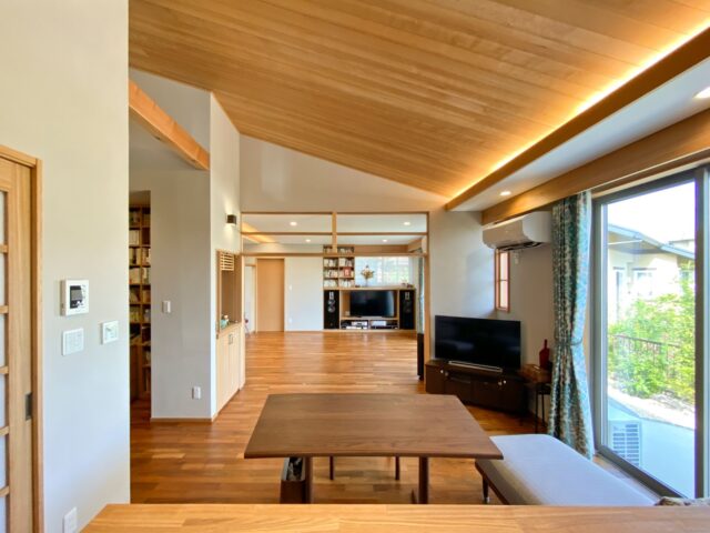 玄関から繋がるダイニングの天井はツガを貼ったもの。屋根形状を活かした高さと南側の大きな窓、隣り合うリビングが一体となり、開放感抜群の空間となっている。