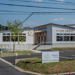 表通りから見た様子。カフェ利用者用の駐車場は、道路から見やすい場所に。建物右が「アート工房ぺがさす」、左が「シャイカフェ」両者の間をアベニューが繋ぐ。