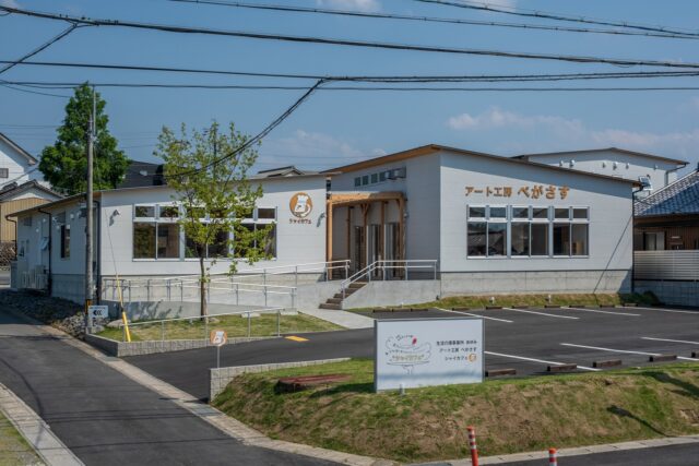 表通りから見た様子。カフェ利用者用の駐車場は、道路から見やすい場所に。建物右が「アート工房ぺがさす」、左が「シャイカフェ」両者の間をアベニューが繋ぐ。