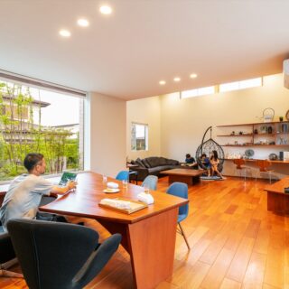 施主様が実際にダイニングテーブルを使用している場面。パソコンを広げたり、夜には庭を眺めながらお酒を楽しんだりすることができる
