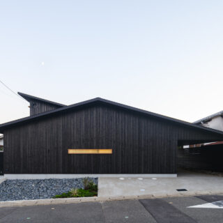 京都らしさを感じさせる焼杉の壁。道路に対しセットバックすることで、地域への圧迫感をなくしつつ、来客用の駐車スペースも確保。