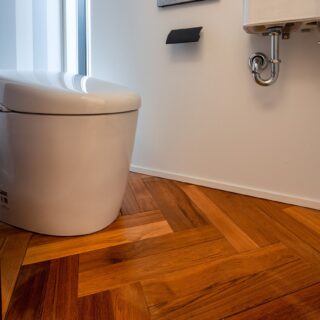 2階のトイレ。床はチークをヘリンボーンで張ってあり、トイレまでもがモダンな印象