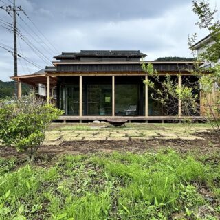 ステイン塗装したスギの外壁は風合いがあって味わい深く、周囲ののどかな景色に馴染みながらも人目を引く。郊外の家は都市部に比べて広い庭を取りやすく、ガーデニングものびのび楽しめる