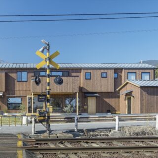 線路から見た外観。2階部分の外壁の凹凸や異なる窓の大きさにより、大きな建物であるにも関わらず、圧迫感のない表情を生みだしている。人通りが多い立地にも関わらず、2階部分のプライバシーが保たれている点にも注目いただきたい
