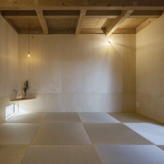 1階の和室。来客用の客間としてだけでなく、カフェの展示スペースとしても活用されている。多目的な使用を想定し、ラワンベニアとシンプルな照明を採用した
