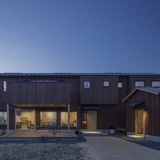 外観夕景。カフェの店内から漏れる光や、テラスやドアを照らす照明が美しい
