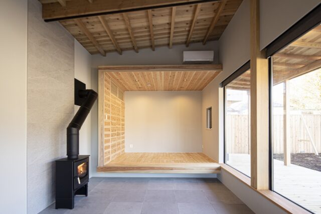 手前がリビング。奥がベッドルーム。「小屋」のイメージで木の質感を生かしたベッドルームは、壁や天井にスギを使用。経年と共に味わいが増すのも楽しみ