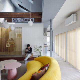 お店みたいにかわいいレトロポップな空間は、居心地も抜群。日中は南一面の連続窓からたっぷりと光が入り、とても明るい。ストリングスカーテンの先は小上がりになった寝室（写真奥）。この小上がりの一部はリビングのベンチとして使える
