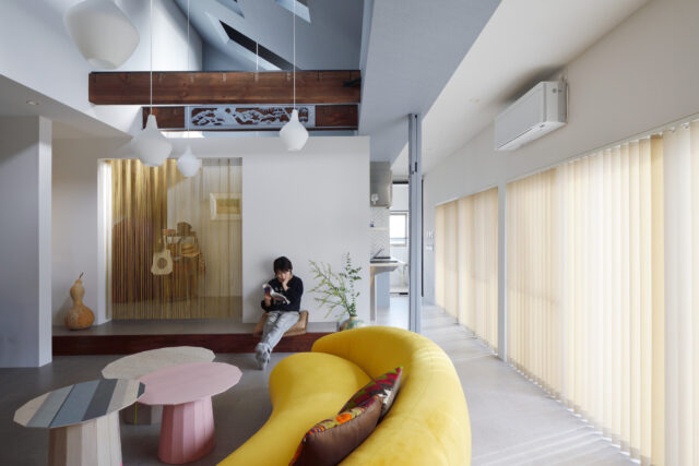 お店みたいにかわいいレトロポップな空間は、居心地も抜群。日中は南一面の連続窓からたっぷりと光が入り、とても明るい。ストリングスカーテンの先は小上がりになった寝室（写真奥）。この小上がりの一部はリビングのベンチとして使える
