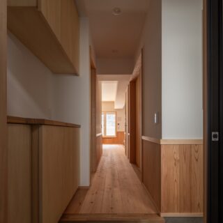 玄関から室内を見る。以前の間取りでは暗く、圧迫感があった。仕切りをなくしたおかげで光が届き明るくなった。廊下の途中、右の引き戸は和室、左の引き戸は洗面脱衣室のもの。まっすぐ窓の方へ進むとLDKがある