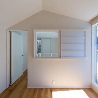 ２階、個室１。屋根の傾斜を生かした天井は、小さな家のようでかわいらしい。画像右、バルコニーに面した窓に加え、吹き抜け側の窓や扉を開ければ複数の方向から光が入り、明るい。室内側にも視線が抜けるおかげで、圧迫感なく過ごせる
