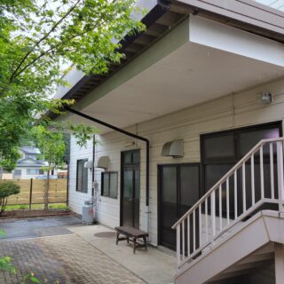 リノベーション前の『飯島の家』。1階は、以前に営業していたスーパーのバックヤードとして使われていた。出入口付近には運搬車両のための車寄せがあり、日差しを遮る大きな庇が付いていて、建物1階にはあまり光が入らなかった
