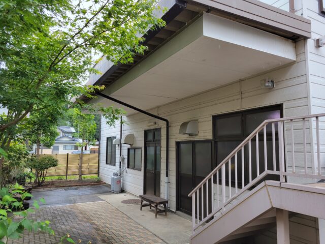 リノベーション前の『飯島の家』。1階は、以前に営業していたスーパーのバックヤードとして使われていた。出入口付近には運搬車両のための車寄せがあり、日差しを遮る大きな庇が付いていて、建物1階にはあまり光が入らなかった
