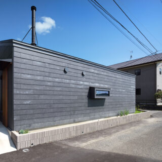 出窓のように飛び出している部分は、キッチンの小窓。通行する人からは中が見えず、キッチンからは田園風景を見ることができる高さに設置されている。片流れの屋根には樋がなく、スッキリしたデザインになっている
