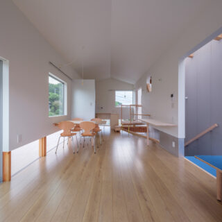 リビングから見た、ダイニングとキッチン。多くの窓と階段上部のトップライトにより、照明がなくてもこの明るさを確保している。ダイニング右の壁にある作り付けのスタディースペースでは、仕事や勉強などができる
