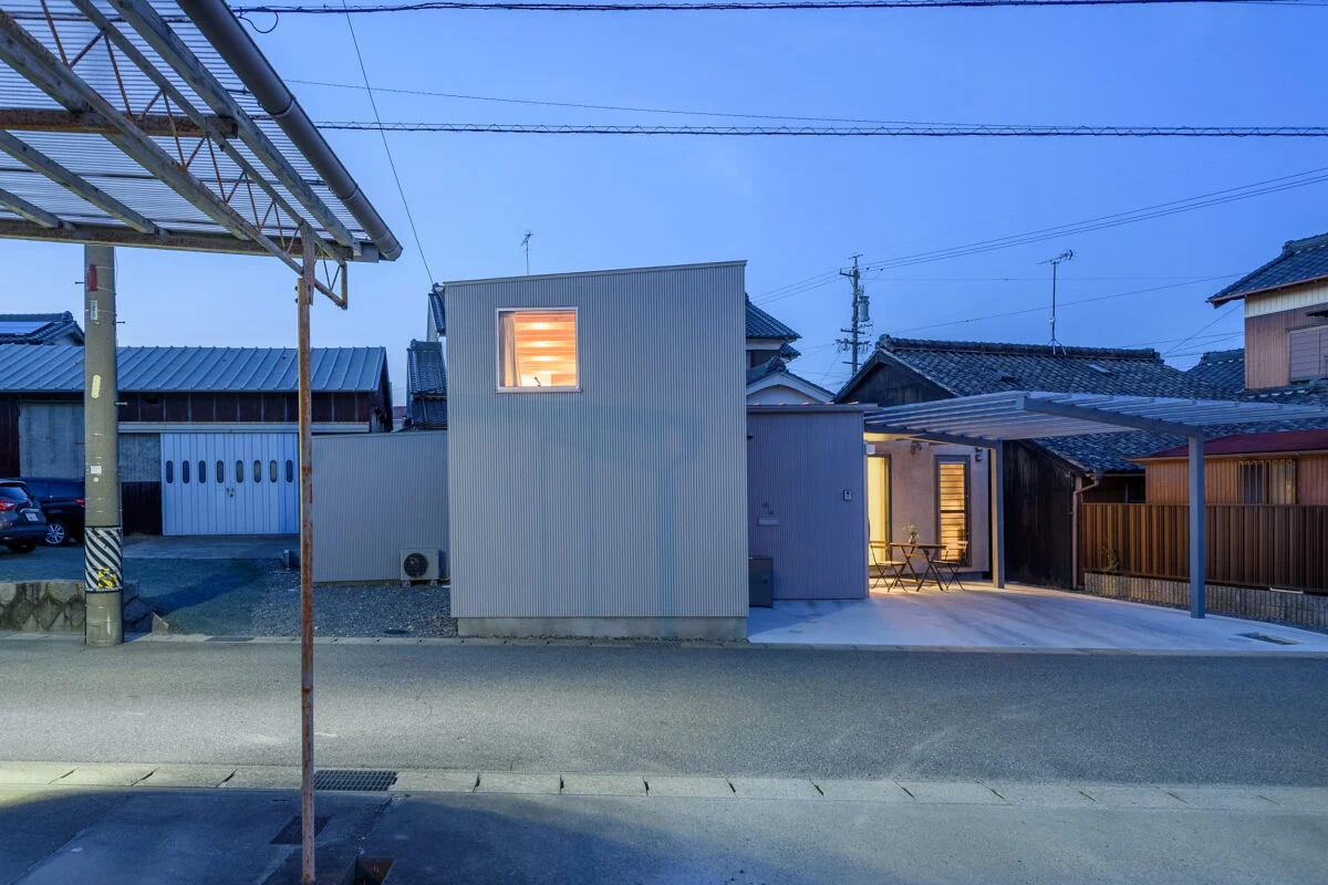 外観夕景。防犯のため道路に面する窓は少ないが、室内から漏れ出る光が美しい
