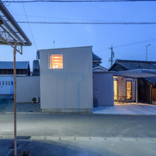 外観夕景。防犯のため道路に面する窓は少ないが、室内から漏れ出る光が美しい
