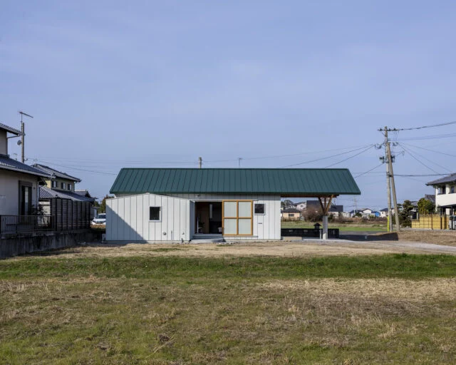 外観（東側）。とても珍しい、大屋根の張り出し。駐車場をすべて覆っていることがわかる。　構造設計の専門家の協力を得て実現した。リビングの大きな引戸は全開することができる

