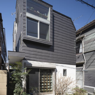 コの字型の部分は写真左奥の建物中央部に配置。エントランスへのアプローチ部分には庇が用意されている
写真　上田宏