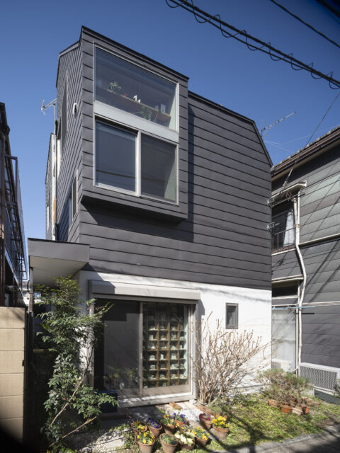 コの字型の部分は写真左奥の建物中央部に配置。エントランスへのアプローチ部分には庇が用意されている
写真　上田宏