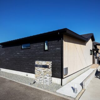 撮影：福澤　昭嘉
壁の一部を杉板とすることで、アクセントをつけた。門柱は砕石を詰め込んだ蛇籠でオブジェのようにも。