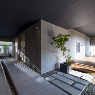 ピロティ（全景）。1階の部屋だった場所を外部化したため、雨や雪を防ぐ広大なエリアが誕生した。降雪地域ではとても便利で重宝しているという。ウッドデッキ（写真右）の前には庭を眺められる浴室窓が設置されている
