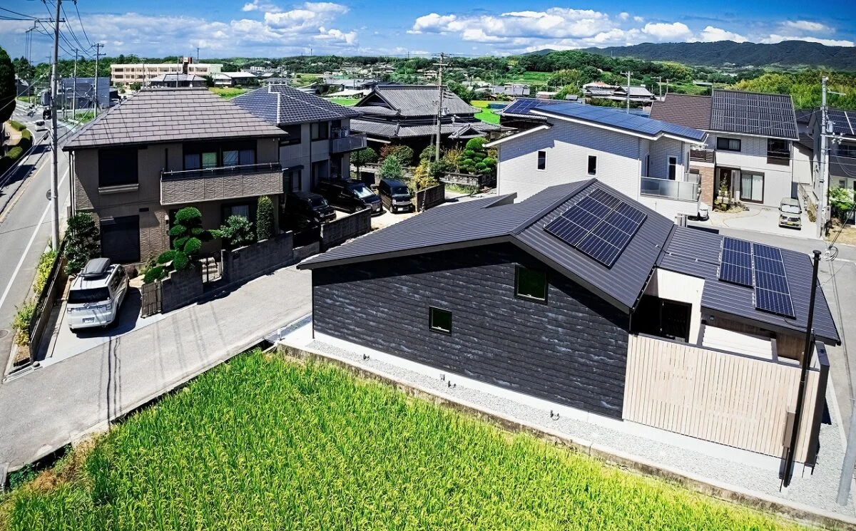 撮影：福澤　昭嘉
付近には住宅や田畑が点在する雰囲気の中に佇むH邸。屋根上の太陽光パネルで発電、蓄電池やエネファームも備え、災害時にも機能停止することがないようにした。