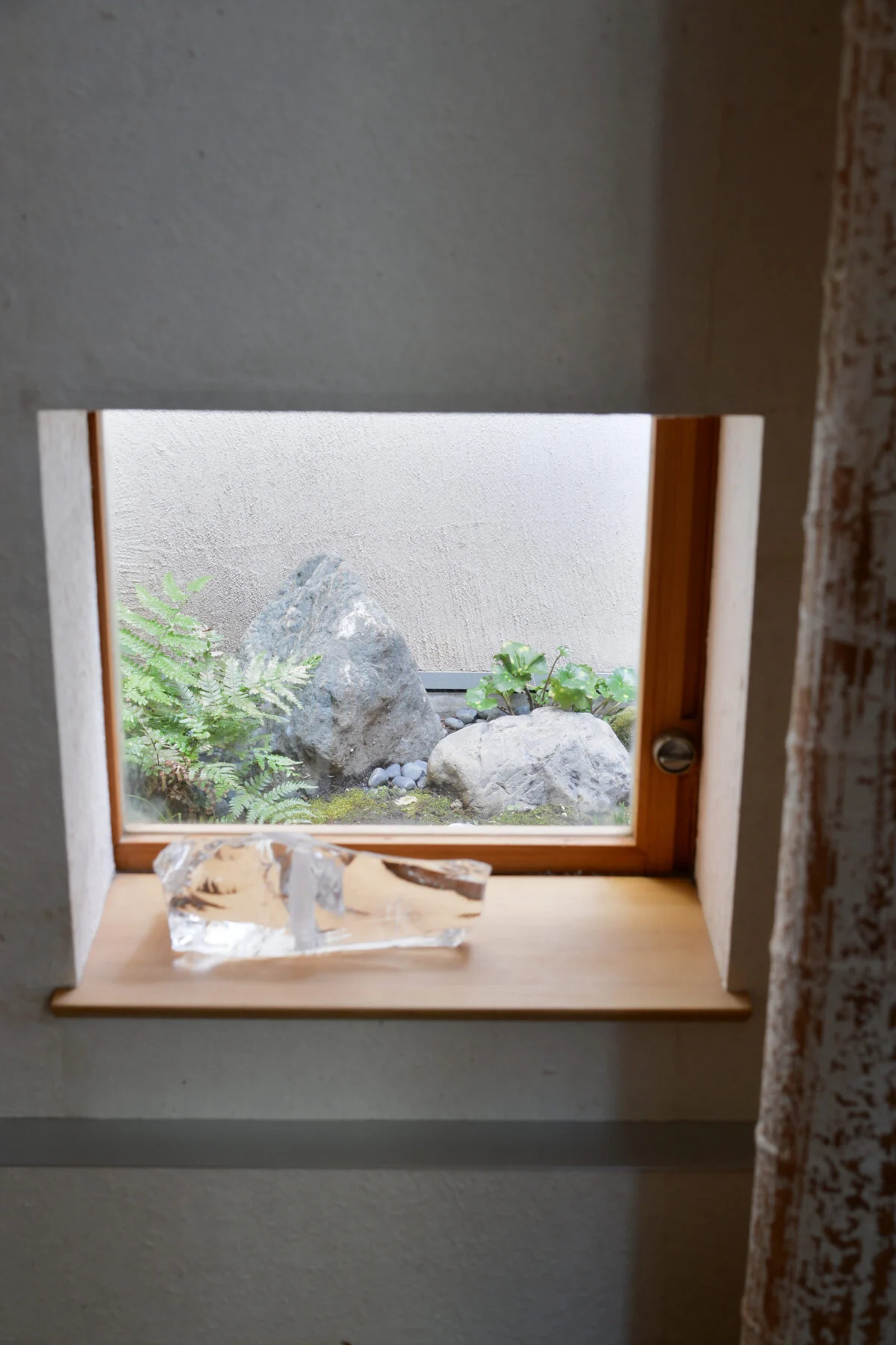 玄関横の部屋に設けられた小窓。来訪者の視線はカットしつつ、坪庭の風景を借景として楽しむことができる
