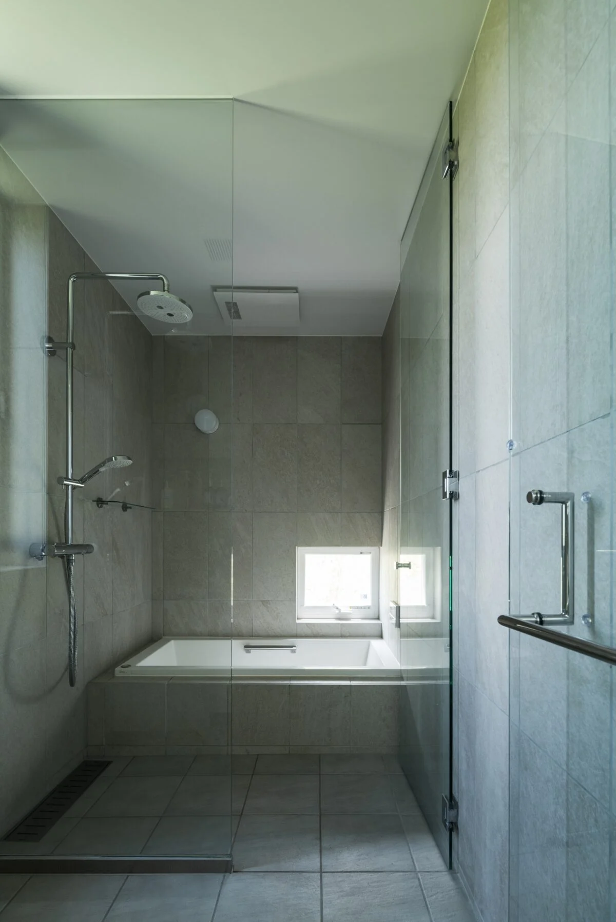 バスルームは、海外のホテルのような雰囲気にするためオーバーヘッドシャワーを採用。窓からは坪庭の景色が見え、プチ露天風呂気分。