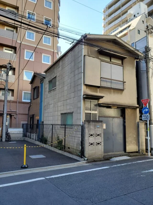 防火地域にある約10坪の土地に建っていた２階建ての旧宅。建物右側と裏には隣家が迫り、後方にも大きな建物があるため、良好な陽当たりが望めない場所だった。
